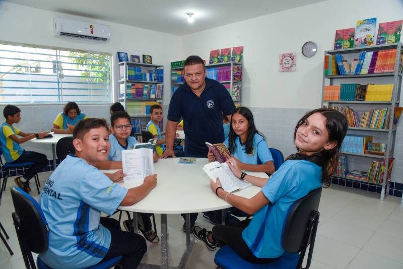 Alunos e professor utilizando a nova sala de leitura 