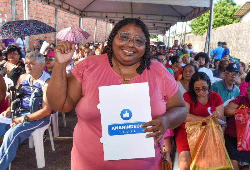 Moradora feliz com seu documento de propriedade.